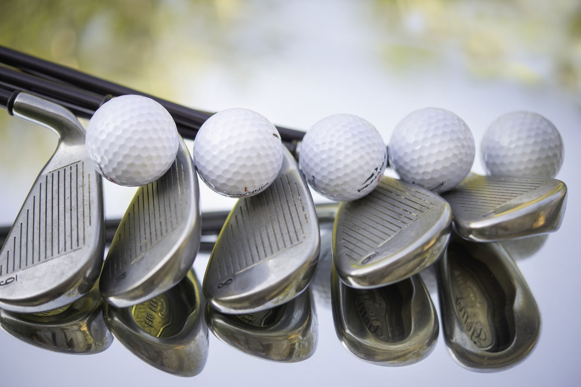 Golf balls and golf clubs on a table