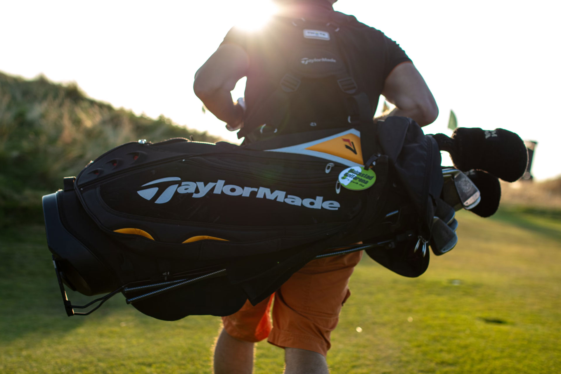 A man carrying a golf bag on the fairway