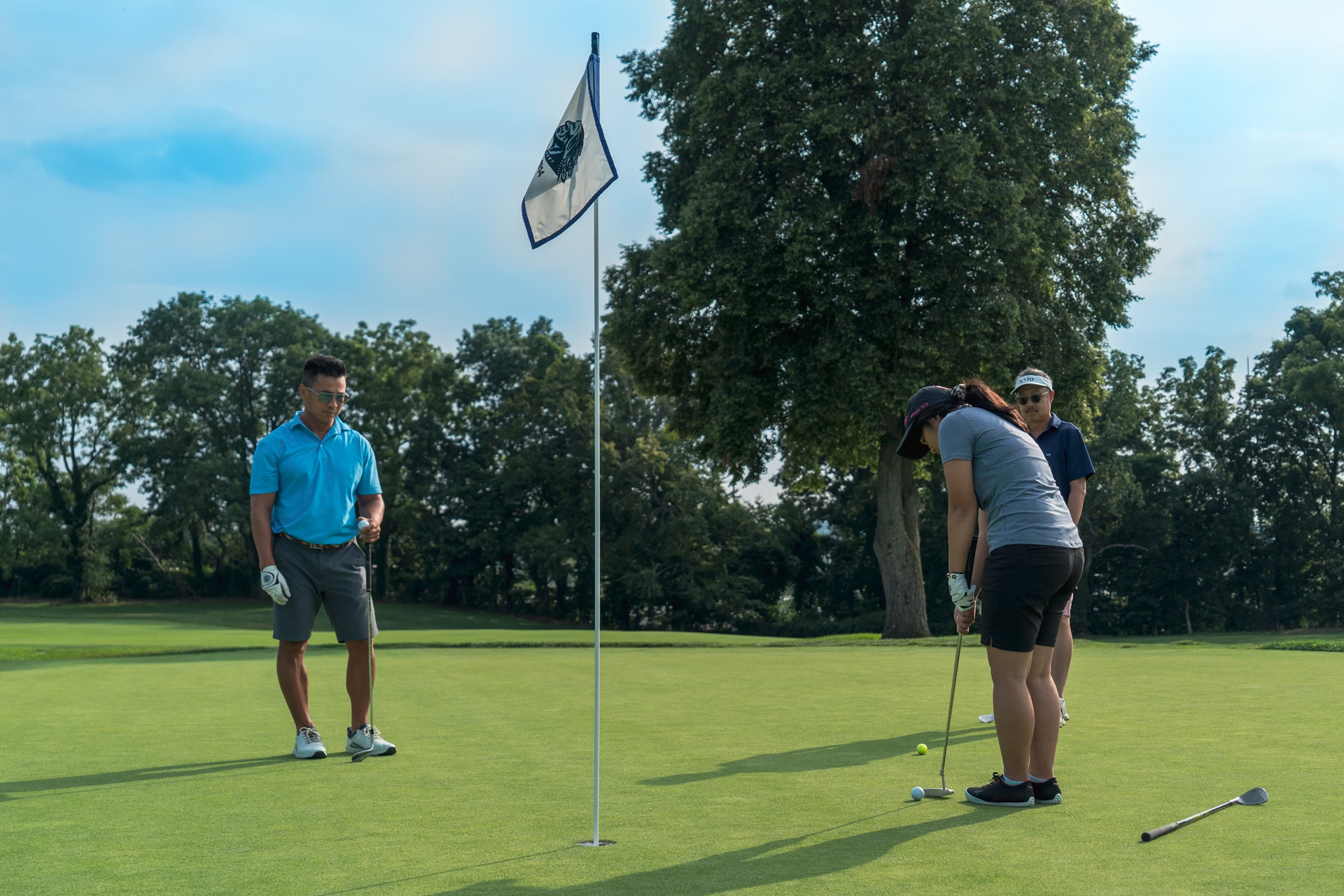 A lady taking a putt towards the hole