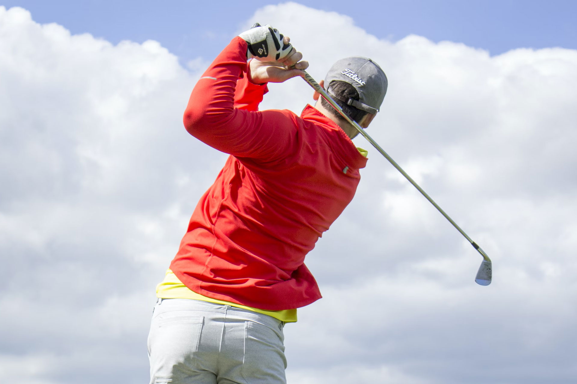 A close up of a man taking a golf shot