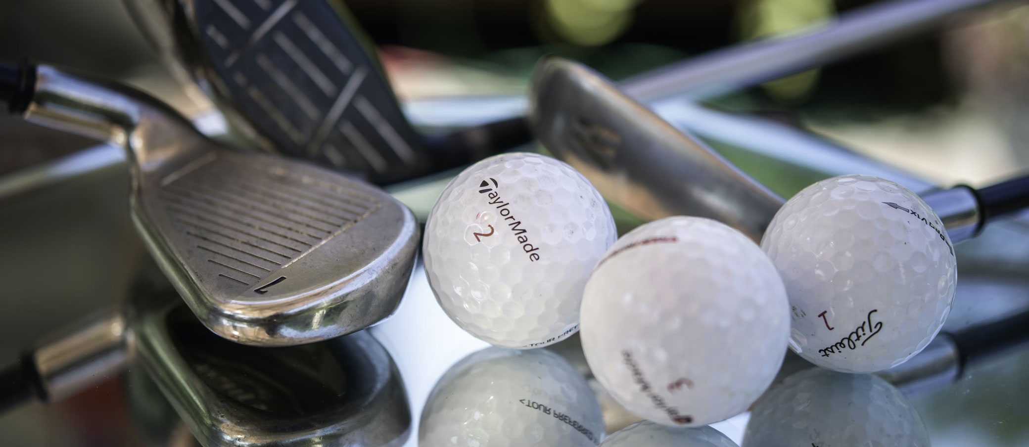 A selection of golf equipment including golf clubs and golf balls.