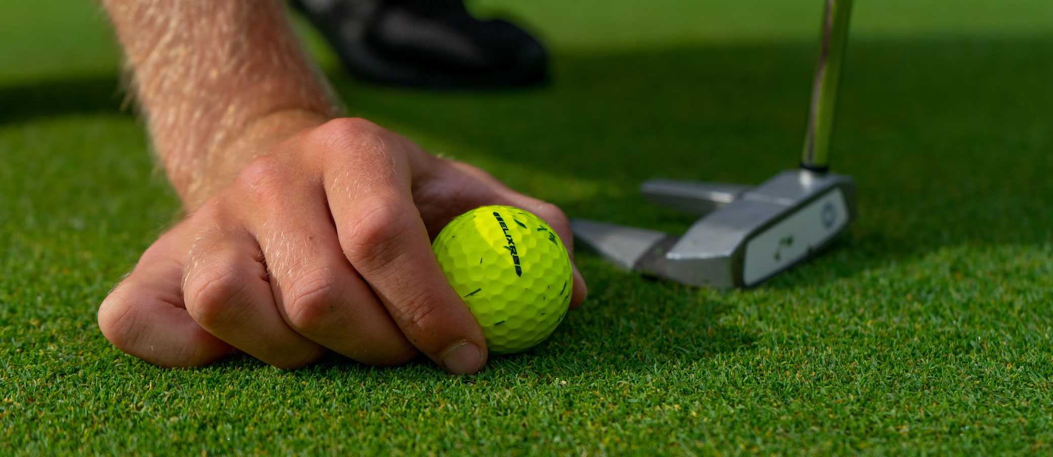 A man placing a golf ball to take another shot.