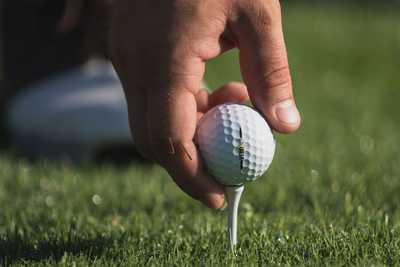 A man placing a ball on a tee ready for his next shot