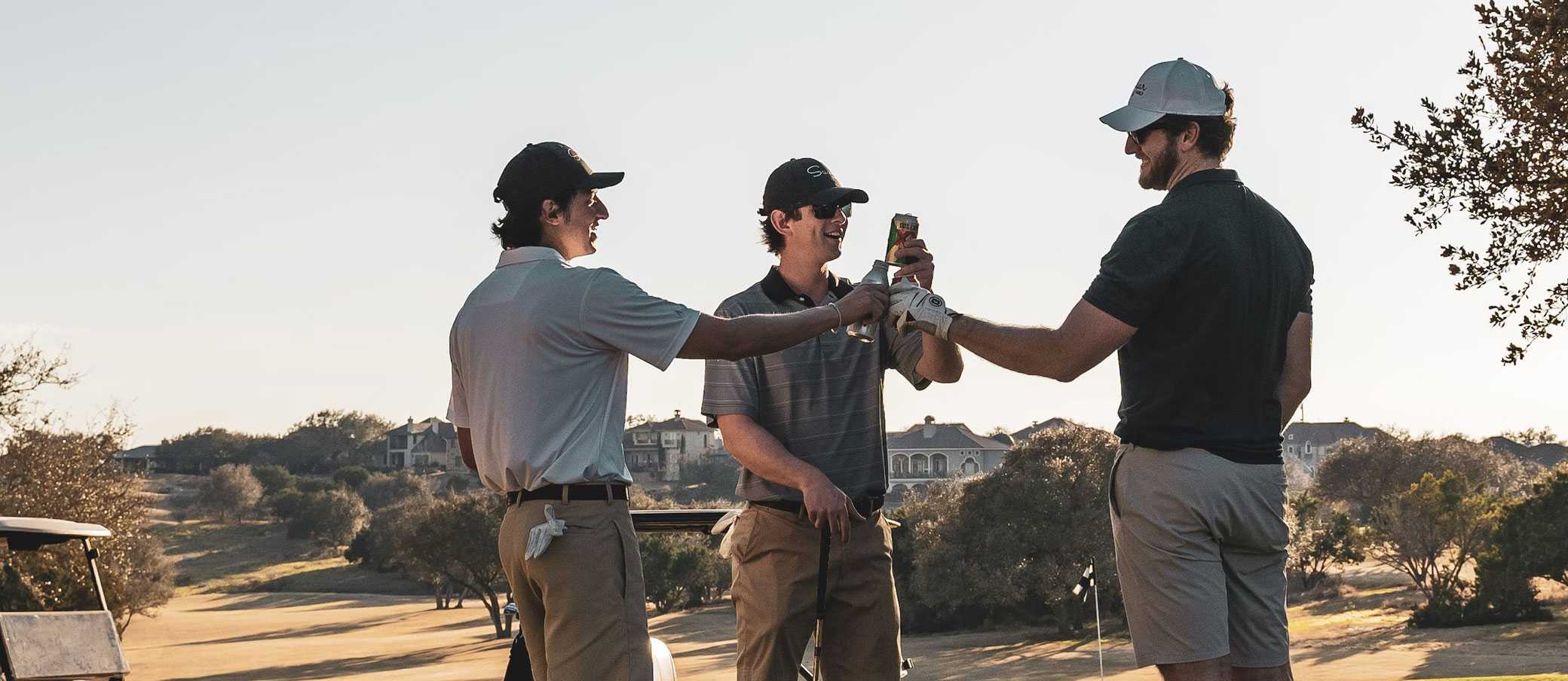 Three golfers cheersing beers after a round of golf.